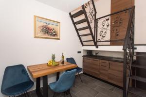 a dining room with a table and blue chairs at Amaizing apartment near Airport in Kastel Stafilic