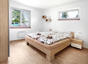 um quarto branco com uma cama grande e 2 janelas em Bungalov - Autokemp Veronika em Chlum u Třeboně