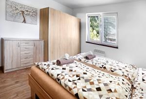 um quarto com uma cama, uma cómoda e uma janela em Bungalov - Autokemp Veronika em Chlum u Třeboně