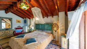 - une chambre avec un grand lit et un plafond en bois dans l'établissement Traditional Cretan Houses,Agios Myronas, à Agios Myronas