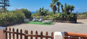 a yard with chairs and a fence and the ocean at La Villa di Nino in Ustica