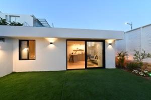 una casa blanca con césped verde en צימר רפאל, en Eilat