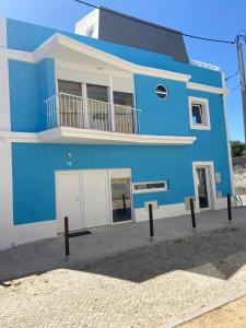 a blue building with a balcony on top of it at Lovers House in Setúbal