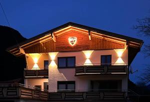 a building with a clock on the side of it at Ferienwohnungen LODGE-B in Weissenbach am Lech