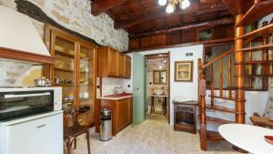 une cuisine avec des placards en bois et un escalier en colimaçon dans l'établissement Traditional Cretan Houses,Agios Myronas, à Agios Myronas