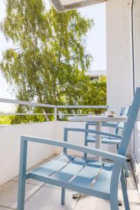 een blauwe tafel en stoelen op een balkon bij Studio 16 "Sandmeer" mit Meerblick in Grömitz