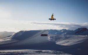 Eine Person, die einen Trick auf einem Snowboard in der Luft macht. in der Unterkunft Hotel Strela by Mountain Hotels in Davos