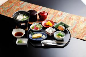 una bandeja de comida en una mesa con tazones de comida en Hanayashiki Ukifune-en, en Uji