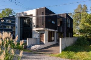 a house with a black and white facade at Asobidokoro in Kutchan