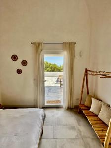 a bedroom with a bed and a sliding glass door at Dimora delle Tonnare in Favignana