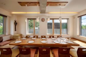 a dining room with a large wooden table and chairs at Asobidokoro in Kutchan