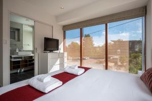 a bedroom with a large white bed and a large window at Asobidokoro in Kutchan