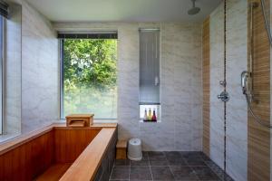 a bathroom with a soaking tub and a window at Asobidokoro in Kutchan +18 photos