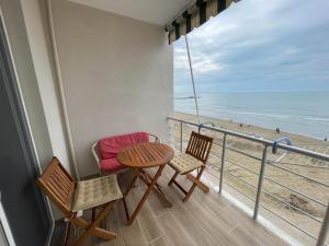 balcón con mesa y sillas y la playa en Bellavista apartment, en Durrës