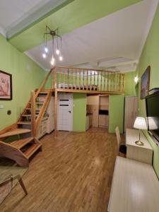Habitación con altillo con escalera y paredes verdes en Ariadna - Pantheon Apartments, en Cracovia
