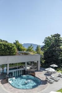 a building with a pool and chairs and an umbrella at Apartments by Bemelmans-Post in Collalbo