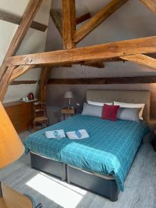 ein Schlafzimmer mit einem Bett in einem Zimmer mit Holzdecken in der Unterkunft Domaine de La Vove in Corbon