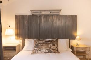 een slaapkamer met een bed met een houten hoofdeinde bij Rubini Uno Guest House in Gradara