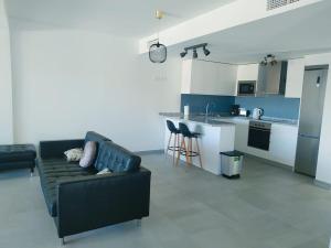 een woonkamer met een zwarte bank en een keuken bij New build Blue sunset large 2 bed apt in Manilva