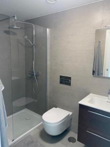 een badkamer met een douche, een toilet en een wastafel bij New build Blue sunset large 2 bed apt in Manilva