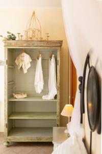 una habitación con un estante con vestidos blancos. en Rubini Uno Guest House, en Gradara