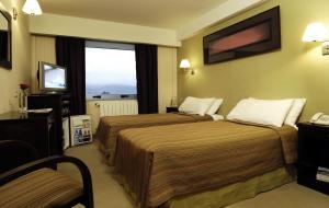 Habitación de hotel con 2 camas y TV en MIL810 Ushuaia Hotel en Ushuaia