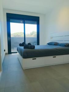 een slaapkamer met een groot bed en een groot raam bij New build Blue sunset large 2 bed apt in Manilva