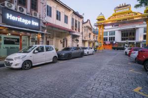 a white car parked on a street in a city at Heritage Inn in George Town