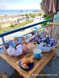 a picnic table with a basket of bread and a view of the beach at Studio 16 "Sandmeer" mit Meerblick in Grömitz