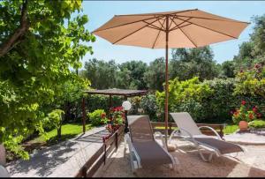 a patio with two chairs and an umbrella at EY House in Halikounas