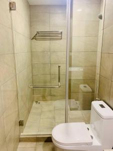 a bathroom with a shower with a toilet and a glass door at Urban Village Night Stay in Phnom Penh