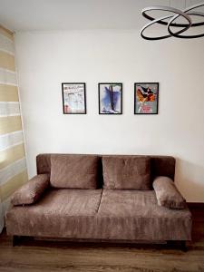 un sofá en una sala de estar con 4 cuadros en la pared en Studio Nebelhorn, en Oberstdorf