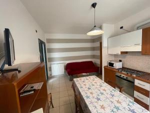 cocina pequeña con mesa pequeña y cocina en Levante Beach via Grado - Agenzia Cocal, en Caorle