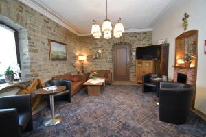 a living room with a couch and chairs and a tv at Akzent Hotel Franziskaner in Dettelbach