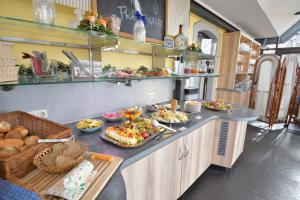 una línea de buffet con muchos platos de comida. en Akzent Hotel Franziskaner, en Dettelbach