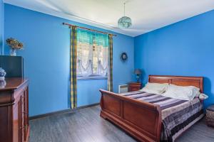 een blauwe slaapkamer met een bed en een raam bij Maison Urt - Charmante maison avec piscine in Urt