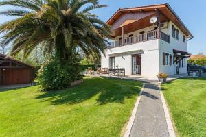 een palmboom voor een huis bij Maison Urt - Charmante maison avec piscine in Urt