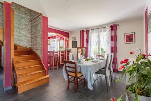 een eetkamer met een tafel en een trap bij Maison Urt - Charmante maison avec piscine in Urt