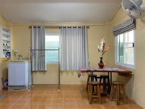 a kitchen with a table and chairs and a window at Tintin home in Chiang Rai