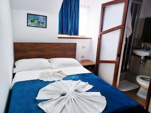 a bedroom with a bed with two towels on it at Pensiunea Filippo in Mila Douăzeci şi Trei