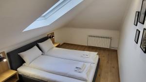 a attic room with two beds and a skylight at Apartments Spring in Čačak