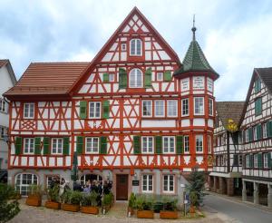 un bâtiment orange et blanc avec une tourelle dans l'établissement Adler Schiltach Boutique Hotel und Restaurant, à Schiltach