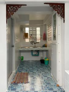 una cucina con pavimento piastrellato e lavandino di Tintin home a Chiang Rai