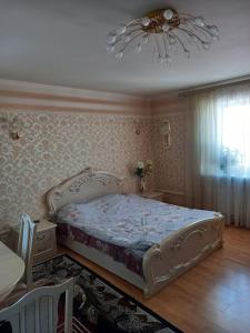Schlafzimmer mit einem Bett und einem Kronleuchter in der Unterkunft Готель Поділля in Shestakovka