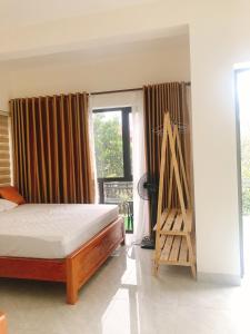 ein Schlafzimmer mit einem Bett und einem Fenster in der Unterkunft Truong Son Luxury Homestay in Ninh Bình
