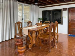 a dining room with a wooden table and chairs at Tintin home in Chiang Rai