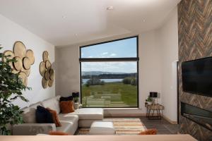 a living room with a couch and a large window at Lochside House Hotel & Spa in New Cumnock