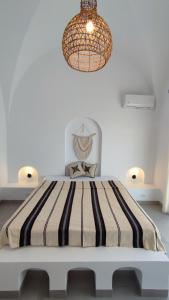a bedroom with a large bed with a chandelier at Villa Pupputia Hammamet M'rezga beach in Nabeul