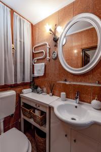 uma casa de banho com um lavatório, um espelho e um WC. em Porta Orientalis em Split