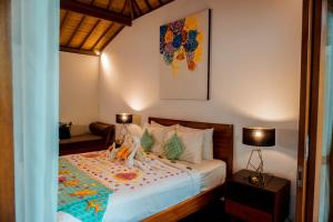 a bedroom with a bed with a colorful blanket on it at Pera ONE Villas in Gili Trawangan +40 photos